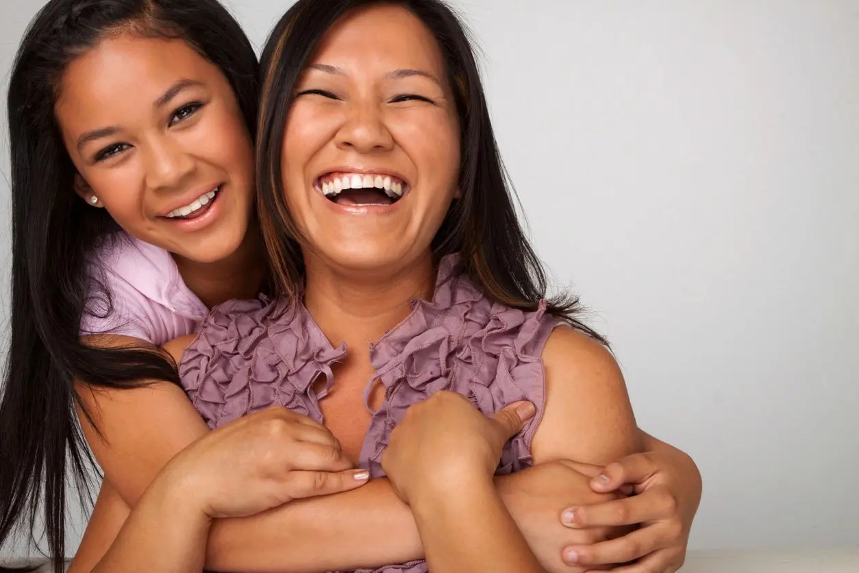 Two women smiling and hugging each other.